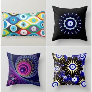 May include: Four different pillow designs featuring the evil eye symbol. The first pillow has a colorful pattern of evil eyes. The second pillow has a black background with a blue evil eye in a white circle. The third pillow has a dark blue background with a pink and gold evil eye. The fourth pillow has a black background with a gold and white evil eye pattern.