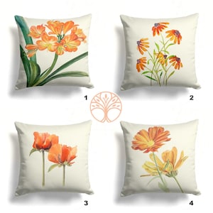 May include: Four square throw pillows with different floral designs. Each pillow features a white background with orange and yellow flowers. The flowers are painted in a watercolor style.
