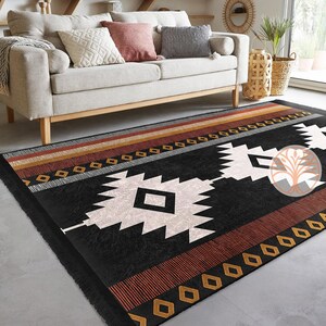 Rug Design Carpet: Black and white geometric patterned rug with red, brown, and gold accents. The rug has a fringe border and is laid out on a light gray floor.