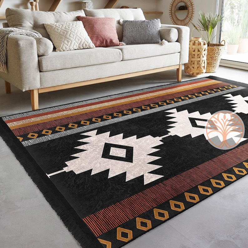 Rug Design Carpet: Black and white geometric patterned rug with red, brown, and gold accents. The rug has a fringe border and is laid out on a light gray floor.