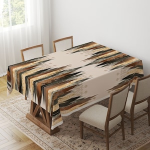 May include: A beige tablecloth with a geometric pattern in shades of brown, black, and gold. The tablecloth is draped over a wooden table with four chairs.