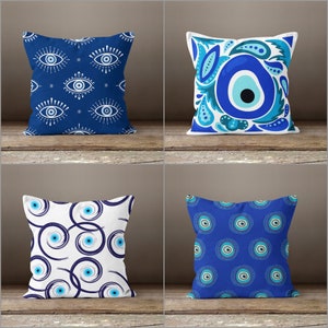 May include: Four different pillow designs featuring the evil eye symbol in blue and white. The evil eye is a symbol of protection against bad luck and misfortune.