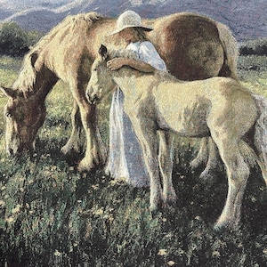 May include: A woven tapestry featuring a scene of a person wearing a white hat and dress standing in a green field with two horses. One horse grazes on the grass while the other stands beside the person. The background shows rolling hills.