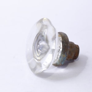 May include: A clear glass door knob with a faceted design and a rusty metal base.