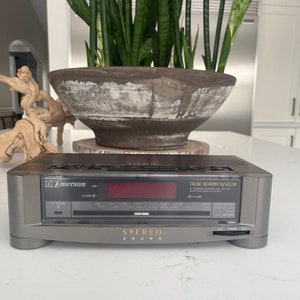 Pu&ograve; includere: Un radio sveglia stereo Emerson grigio con un sistema di doppia sveglia e un display digitale rosso. La radio ha un sintonizzatore digitale con bande AM e FM e un lettore di cassette. Il radio sveglia ha un sistema di doppia sveglia con un pulsante snooze.