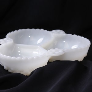 May include: White milk glass divided serving dish with three sections. The dish has a scalloped edge and a beaded design.