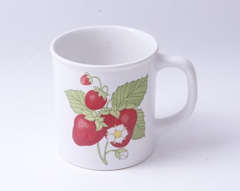 May include: White ceramic mug with a handle, featuring a red and green strawberry design.