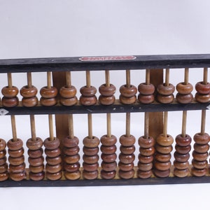 May include: A wooden abacus with brown beads and a black frame. The abacus has two rows of beads and is a traditional counting tool.