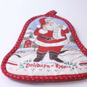 May include: Red and white Christmas pot holder with a Santa Claus illustration and the text "Holidays at Home".