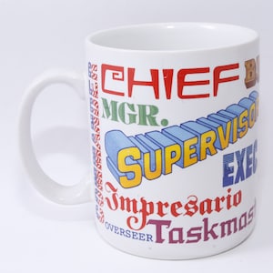 Könnte beinhalten: Weißer Keramikbecher mit Henkel, verziert mit farbigen Schriftzügen wie "CHIEF" und "SUPERVISOR." Das Design des Bechers zeigt verschiedene Berufsbezeichnungen in unterschiedlichen Schriftarten und Farben, ideal fürs Büro.