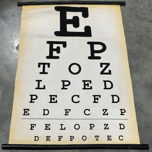 May include: A white ceramic mug with a black handle and the text "But First, Coffee" in a black, handwritten-style font. The mug is on a white surface.