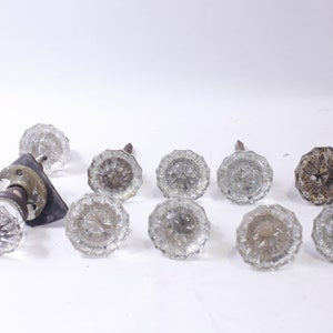 以下が含まれることがあります： ファセットデザインのアンティークガラス製のドアノブ10個セット。ノブは、わずかに琥珀色の透明ガラス製で、真鍮仕上げです。ノブは、多少の摩耗がありますが、良好な状態です。