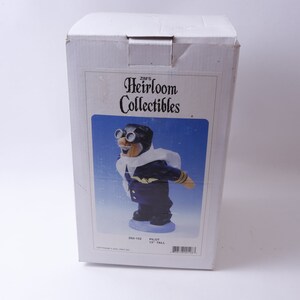 May include: A white box with a blue and white image of a pilot wearing a scarf and goggles. The box says "Zims Heirloom Collectibles" and "Pilot 12" tall.
