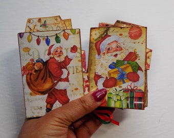 Pode incluir: Dois conjuntos de cartões de Natal feitos à mão com ilustrações vintage do Papai Noel. Um conjunto de cartões apresenta o Papai Noel carregando uma bolsa de presentes e um urso de pelúcia. O outro conjunto de cartões apresenta o Papai Noel segurando uma pilha de presentes embrulhados. Ambos os conjuntos de cartões têm um esquema de cores vermelho, verde e branco.
