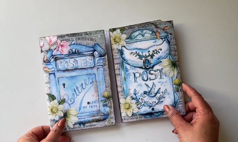 May include: Two vintage-style blue mailboxes with floral accents. The mailbox on the left says "POSTES" and "Lettres" with the text "LEV&Eacute;E EST FAITE". The mailbox on the right says "POST" with a small bird illustration. Both mailboxes have a white background with a floral design.