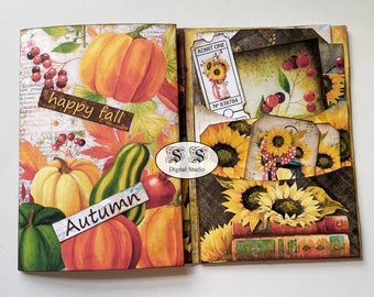 May include: A scrapbook with a fall theme. The front cover features pumpkins, gourds, and leaves in shades of orange, yellow, and green. The text "happy fall" and "Autumn" are printed on the cover. The back cover features sunflowers, a ticket, and a tag with the text "N° 838794".