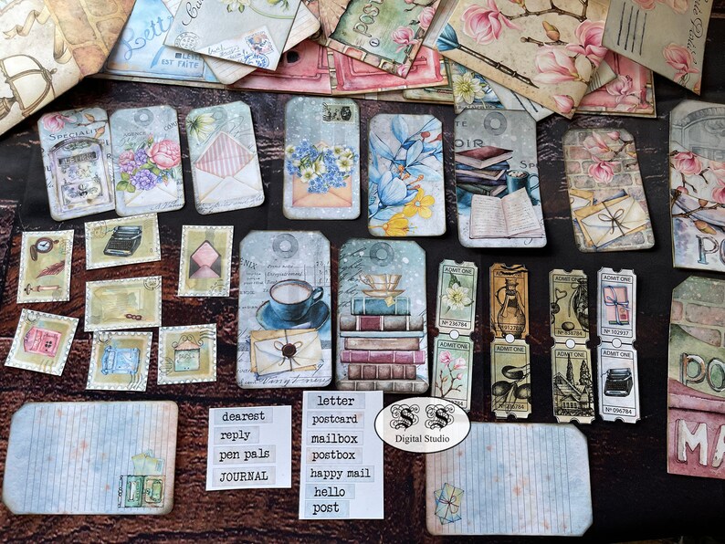 May include: A collection of vintage-style paper ephemera with a postal theme. The ephemera includes tags, stamps, and postcards with images of letters, mailboxes, and books. The text on the ephemera includes words like "letter", "postcard", "mailbox", "dearest", "reply", "pen pals", "journal", "happy mail", "hello", and "post".
