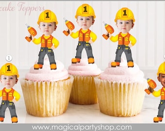 May include: Four cupcake toppers featuring a cartoon construction worker holding a drill. The worker is wearing a yellow hard hat, orange vest, and blue jeans. The toppers are printed with the number "1" on the hard hat. The cupcake toppers are on top of cupcakes with pink frosting.