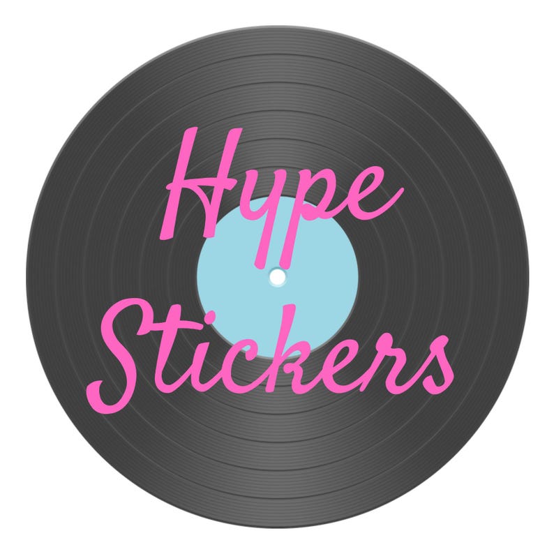 Pu&ograve; includere: Un disco in vinile nero con un'etichetta blu chiaro e il testo "Hype Stickers" in corsivo rosa.