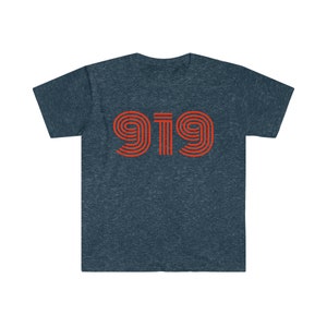 May include: A navy blue t-shirt featuring the number "919" in a retro orange font. The text is centered on the chest. The shirt has short sleeves and a crew neck.
