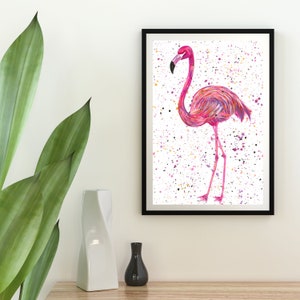 May include: A pink flamingo illustration with a white background and colorful splatter paint. The flamingo is standing on one leg with its head tilted to the side.