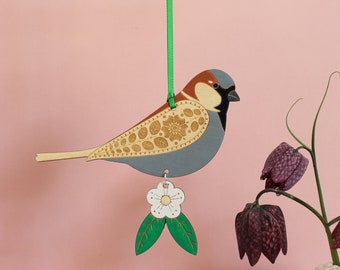サンザシの花が飾られた、吊り下げ式のスズメの木製鳥飾り