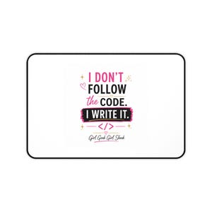 Può includere: Un tappetino da scrivania rettangolare con sfondo bianco e bordo nero. Al centro è presente il testo I DON'T FOLLOW the CODE. I WRITE IT. in rosa e nero, con un simbolo di parentesi di codice, piccoli cuori, stelle e il testo Girl Geek Girl Sheek.