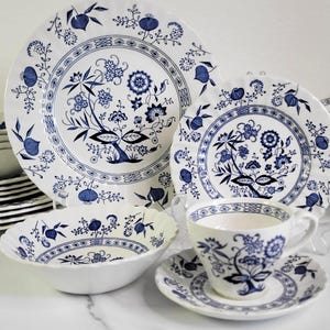May include: A set of blue and white floral patterned china dinnerware, including a dinner plate, salad plate, bowl, teacup, and saucer.