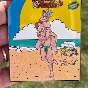 Puede incluir: Una portada de cómic con Jughead y Archie en una playa. La portada es amarilla con un cielo azul y una nube blanca. El título del cómic es "Jughead and Archie" y el texto "ARCHIE! WE ARE READY TO BE UNBURIED! ARCHIEEE!!!" está impreso en la portada.
