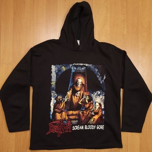 Puede incluir: Sudadera con capucha negra con un estampado gráfico de una banda llamada "Death" con el texto "Scream Bloody Gore".