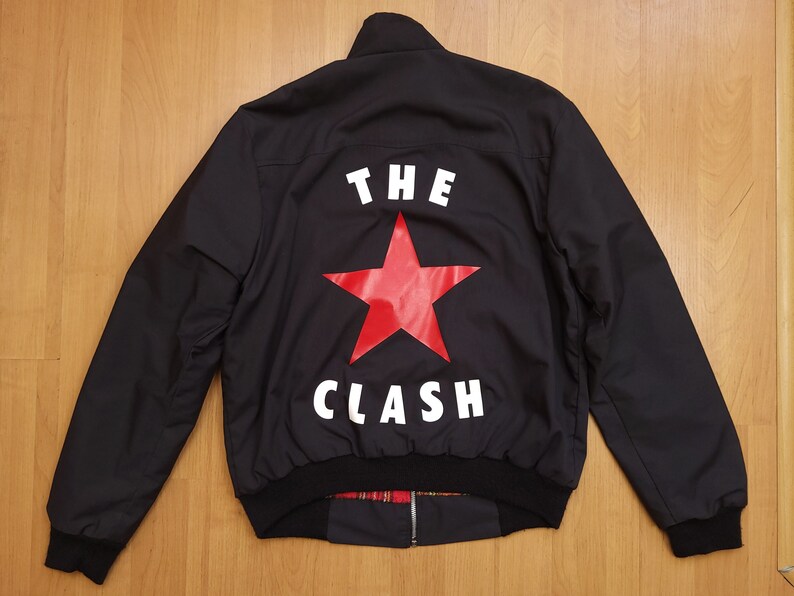 Peut inclure: Blouson noir avec une &eacute;toile rouge et le texte "THE CLASH" imprim&eacute; au dos.