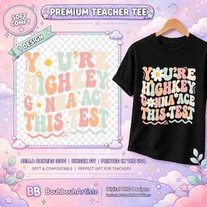 May include: A black t-shirt featuring the text "YOU'RE HIGHKEY GONNA ACE THIS TEST" in a wavy, multi-colored font with small white daisy graphics. The design is displayed on a wooden hanger against a background with clouds and stars.