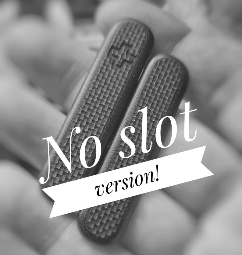 Puede incluir: Dos objetos rectangulares oscuros y texturizados se sostienen en una mano borrosa. Los objetos tienen un patr&oacute;n repetitivo. El texto blanco en una pancarta blanca dice "No slot version!"