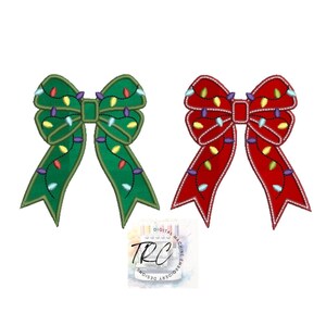 May include: Two Christmas bows with lights. One bow is green and the other is red.