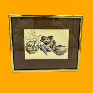 Peut inclure: Peinture à l'aquarelle encadrée représentant trois vases en poterie décoratifs et un épi de maïs. La poterie est ornée de motifs géométriques et floraux. L'œuvre est sur fond neutre et encadrée en or.