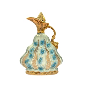 May include: A decorative ceramic pitcher with a gold handle, spout, and lid. The body is light blue with gold and blue floral patterns. The pitcher has a bulbous shape and a decorative base.
