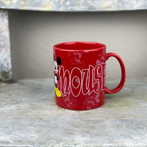 Pu&ograve; includere: Tazza in ceramica rossa con un contorno bianco di Topolino e la parola "Mouse" sul davanti. La tazza &egrave; decorata con un motivo di silhouette di Topolino.