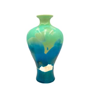 May include: A green and blue ceramic vase with a rounded body and a narrow neck. The vase has a mottled, abstract design.