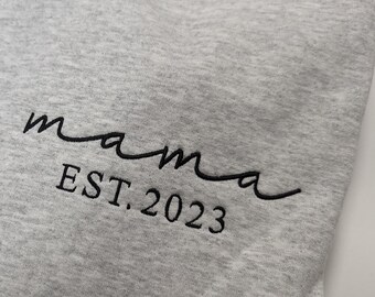 May include: Gray sweatshirt with black embroidered text that reads "mama est. 2023".