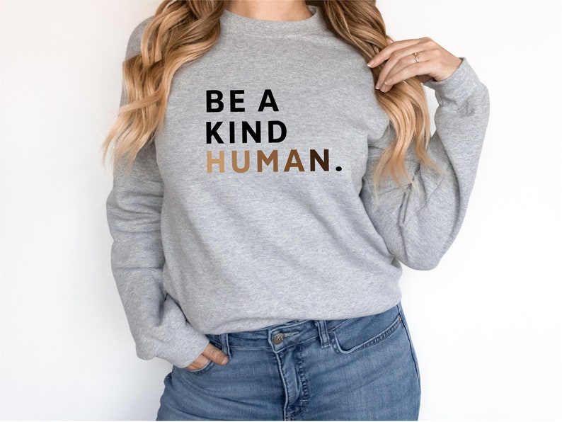 May include: A grey sweatshirt with the text "BE A KIND HUMAN." printed in black and brown.