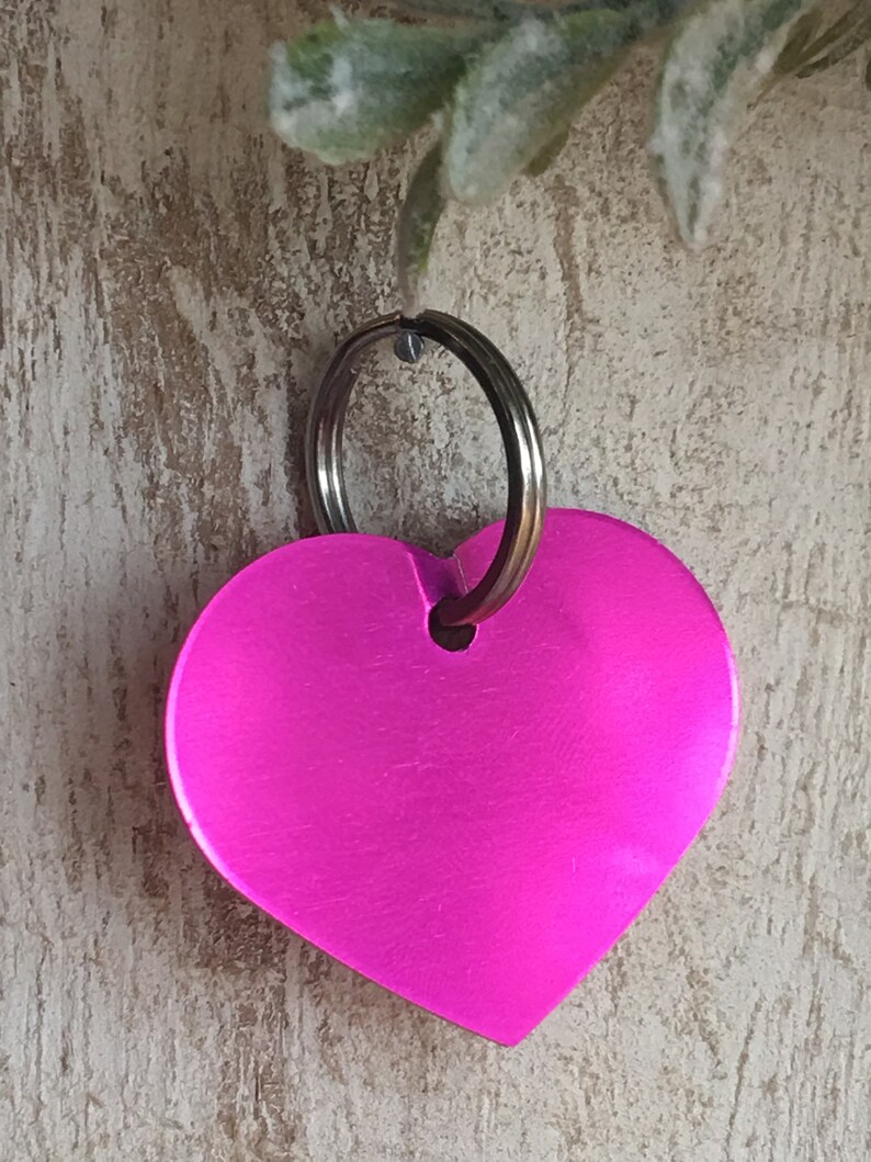 May include: A bright pink heart-shaped keychain with a silver key ring.