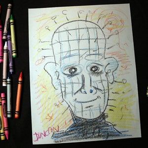 May include: A drawing of a face with a grid pattern on the forehead and a smile. The drawing is done in blue, yellow, and red crayon on white paper. The signature "Duncan" is written in pink crayon at the bottom of the page.