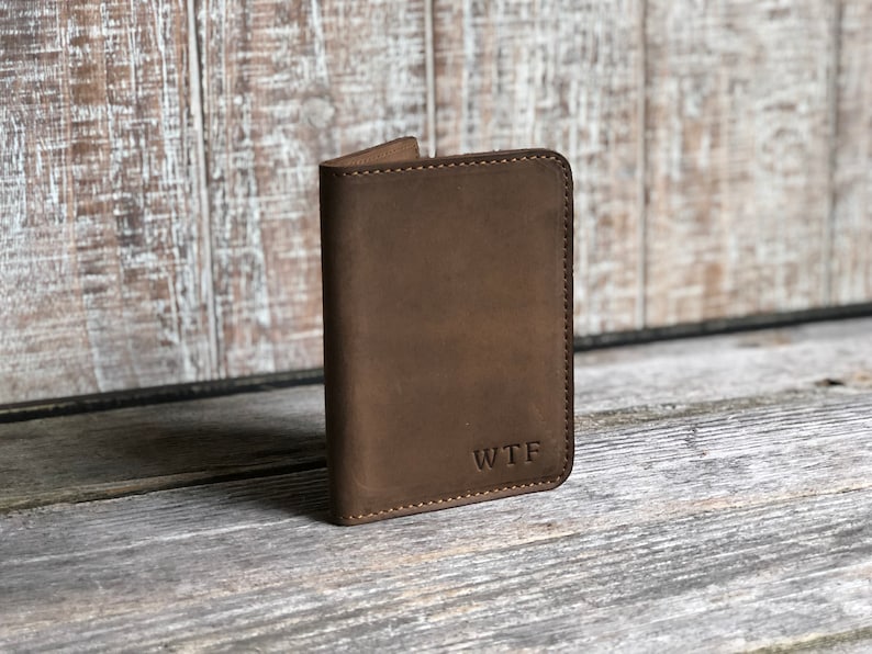 May include: A brown leather wallet with the initials "WTF" embossed on the front.
