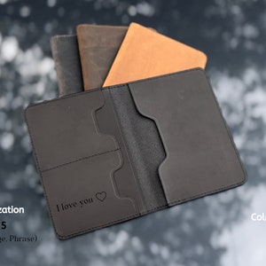May include: Black leather passport holder with a flap closure and two interior pockets. The holder is personalized with the text "I love you" and a heart symbol.