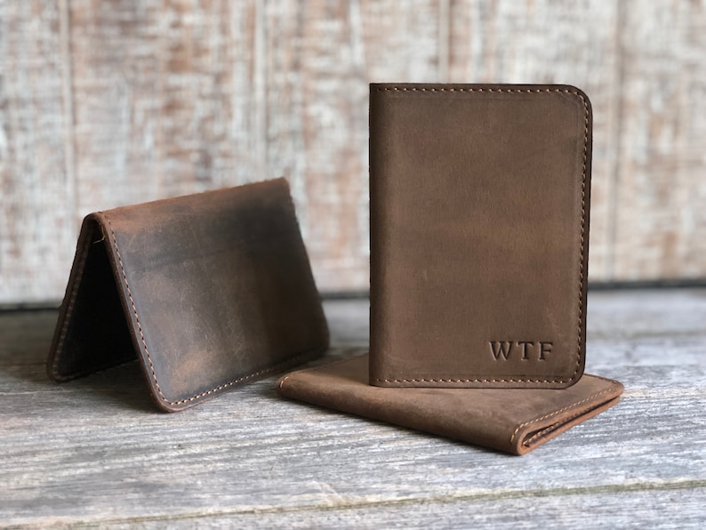 May include: Two brown leather wallets, one with the initials "WTF" embossed on the front.