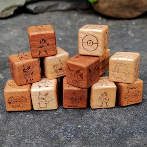 Könnte beinhalten: Eine Sammlung von hellen und dunkelbraunen Holzwürfeln mit lasergravierten Abbildungen verschiedener Kreaturen und einem kreisförmigen Emblem. Der Text Wood Tactics LLC ist in der unteren rechten Ecke des Bildes zu sehen.