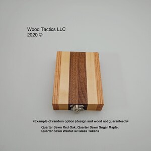 May include: A wooden box with a hinged lid and a metal latch. The box is made of three different types of wood: quarter sawn red oak, quarter sawn sugar maple, and quarter sawn walnut. The box is labelled "=Example of random option (design and wood not guaranteed)=" and "Quarter Sawn Red Oak, Quarter Sawn Sugar Maple, Quarter Sawn Walnut w/ Glass Tokens".