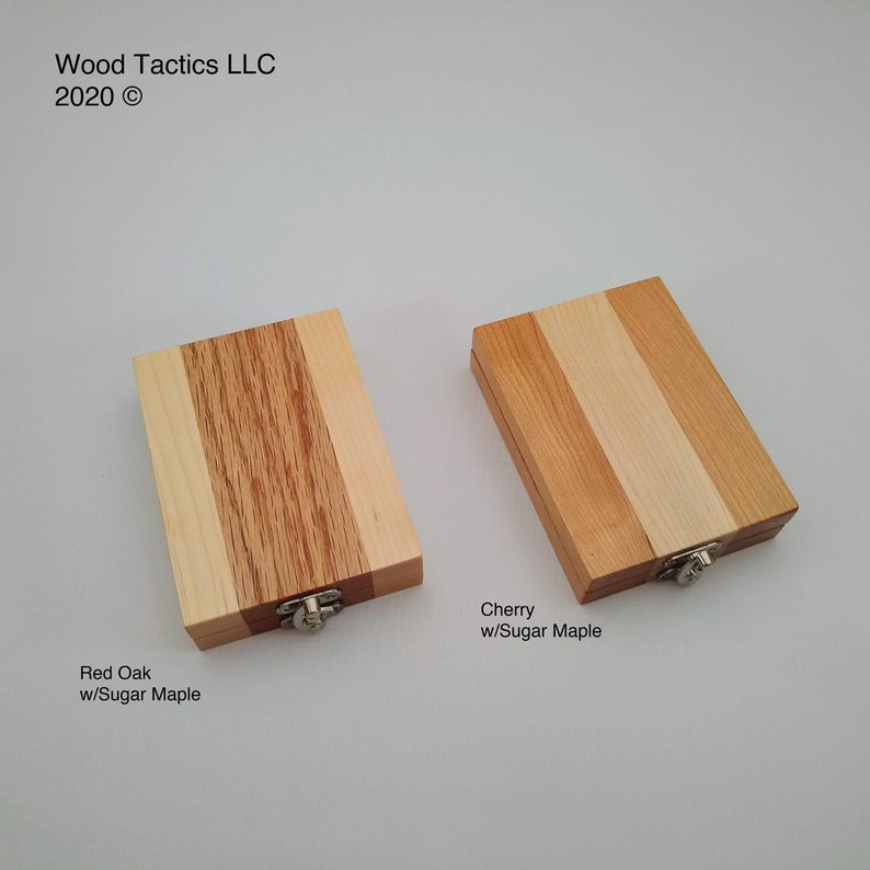 May include: Two wooden boxes with hinged lids, each made of three different types of wood. The box on the left is labelled "Red Oak w/Sugar Maple" and the box on the right is labelled "Cherry w/Sugar Maple".