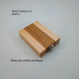 May include: A small wooden box with a hinged lid and a metal clasp. The box is made from two types of wood: white oak and red leaf maple. The wood is arranged in alternating stripes.