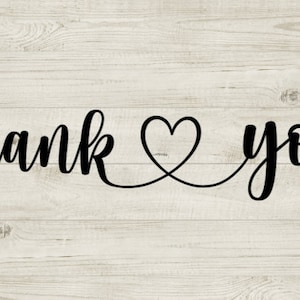 以下が含まれることがあります： 明るい木製の背景に黒い筆記体で「ありがとう」と書かれており、単語の間にハートが描かれています。